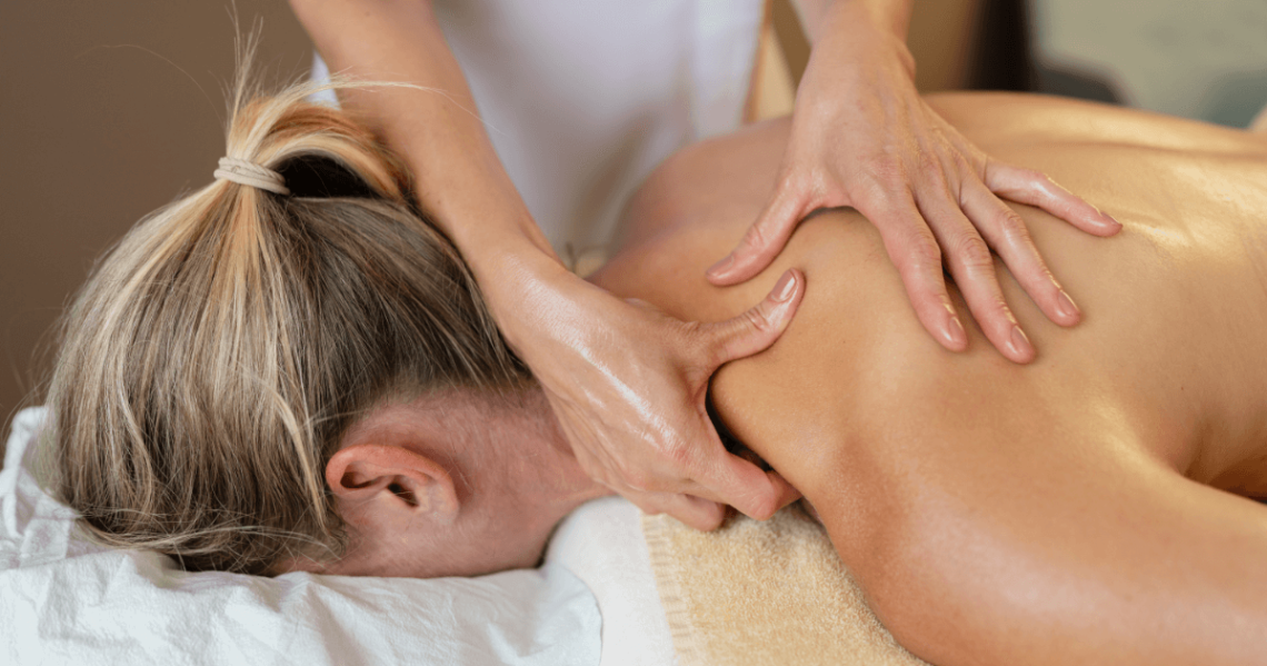 Mulher recebendo massagem terapêutica nas costas, com foco em alívio muscular e bem-estar físico.
